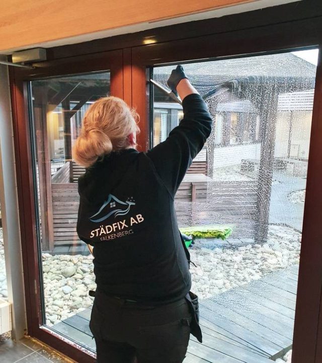 Fönsterputsare som rengör stora fönster med professionell utrustning.