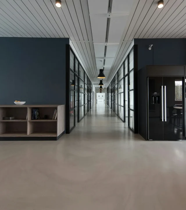 Arbetsplats i kontorsmiljö med skrivbord, kontorsstolar och datorutrustning.