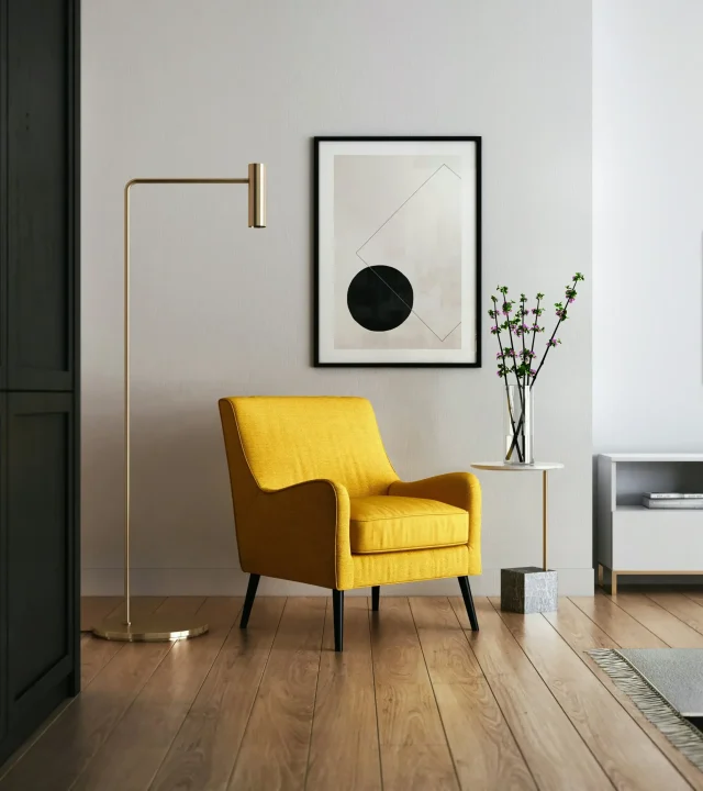 Modernt inrett hem med stilren design och en gul stol som färgaccent.