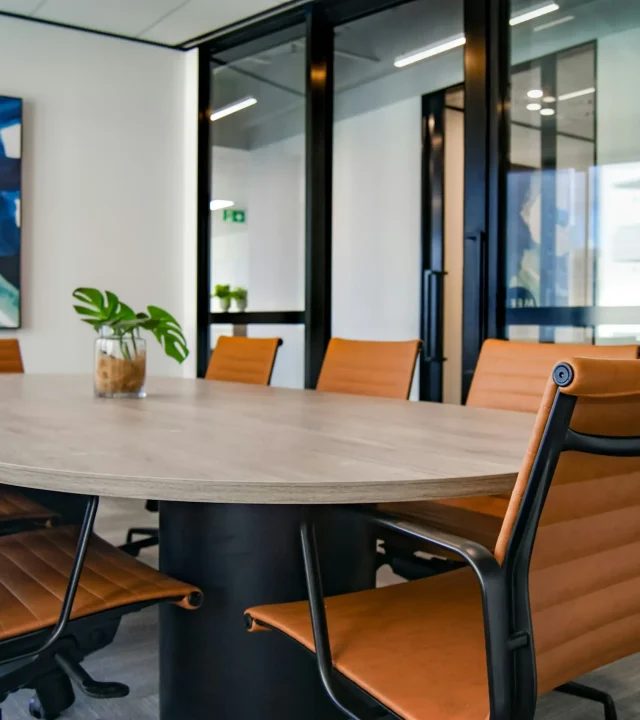 Modernt kontor med skrivbord, stolar och organiserad arbetsmiljö.